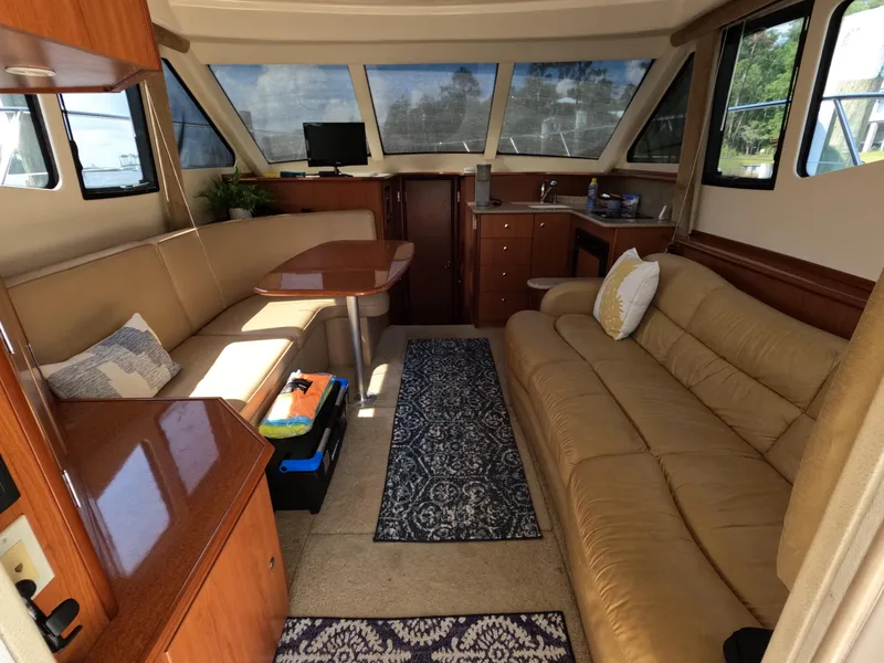 Slide: The Image of Interior of 2008 Silverton 33 Convertible yacht with sofas, table, and kitchenette. - 13