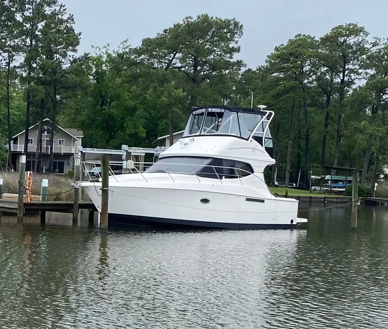 Slide: The Image of 2008 Silverton 33 Convertible yacht docked by a lakeside with trees in the background. - 4