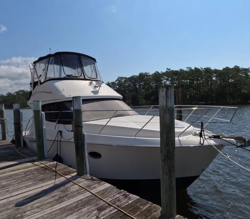 Slide: The Image of 2008 Silverton 33 Convertible yacht docked by a wooden pier on a sunny day. - 5