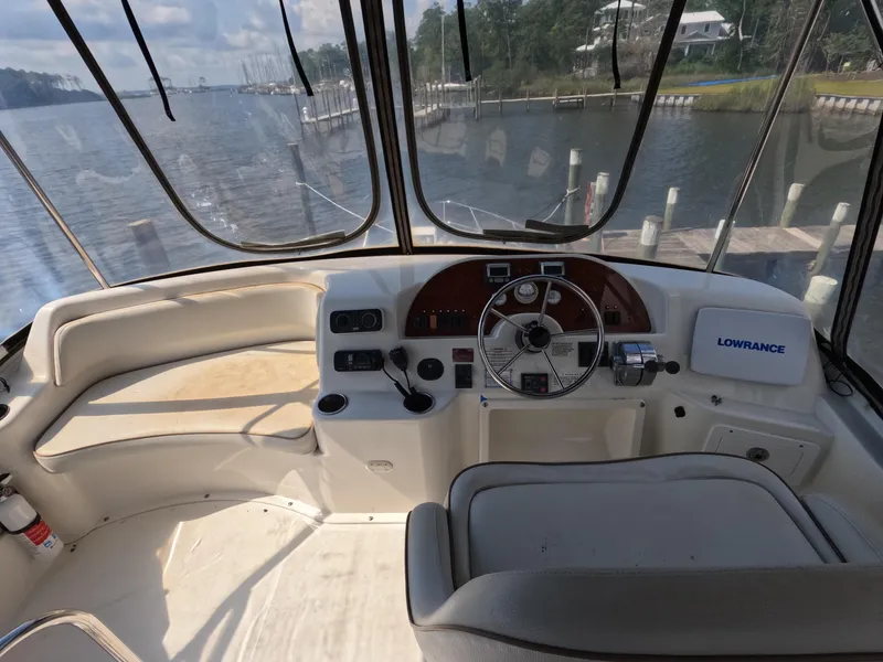 Slide: The Image of 2008 Silverton 33 Convertible boat helm with Lowrance system, docked by a scenic waterfront. - 8