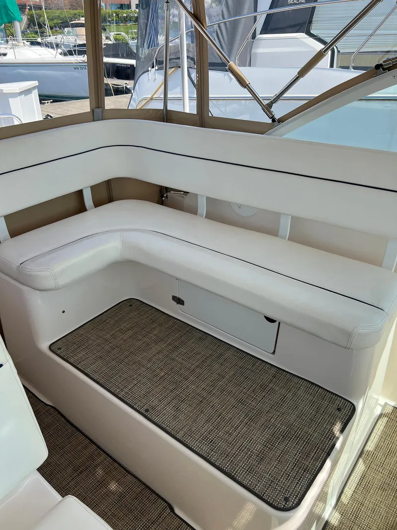 Slide: The Image of 2006 Tiara Yachts 2900 Coronet interior with white seating and carpeted floor. - 16