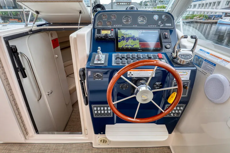 Slide: The Image of 2006 Tiara Yachts 2900 Coronet helm with navigation controls and wooden steering wheel. - 20