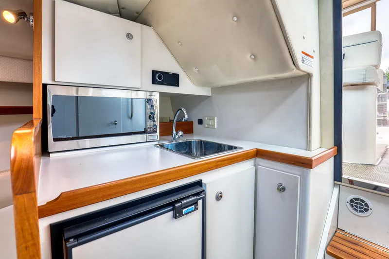 Slide: The Image of 2006 Tiara Yachts 2900 Coronet interior kitchen with microwave, sink, and compact fridge. - 24