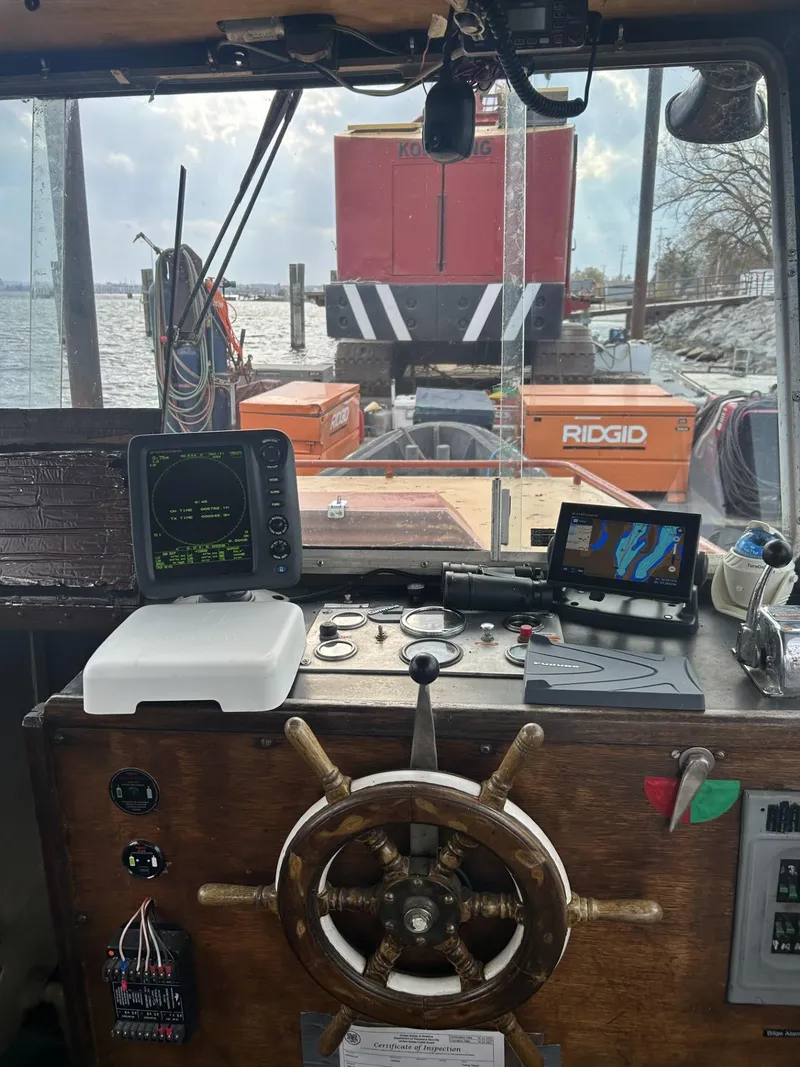 Slide: The Image of Vintage boat cockpit with steering wheel, navigation equipment, and view of docked barge. - 4