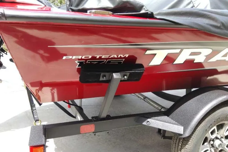 Slide: The Image of 2025 Tracker Pro Team 175 boat on trailer, red exterior with branding visible. - 66