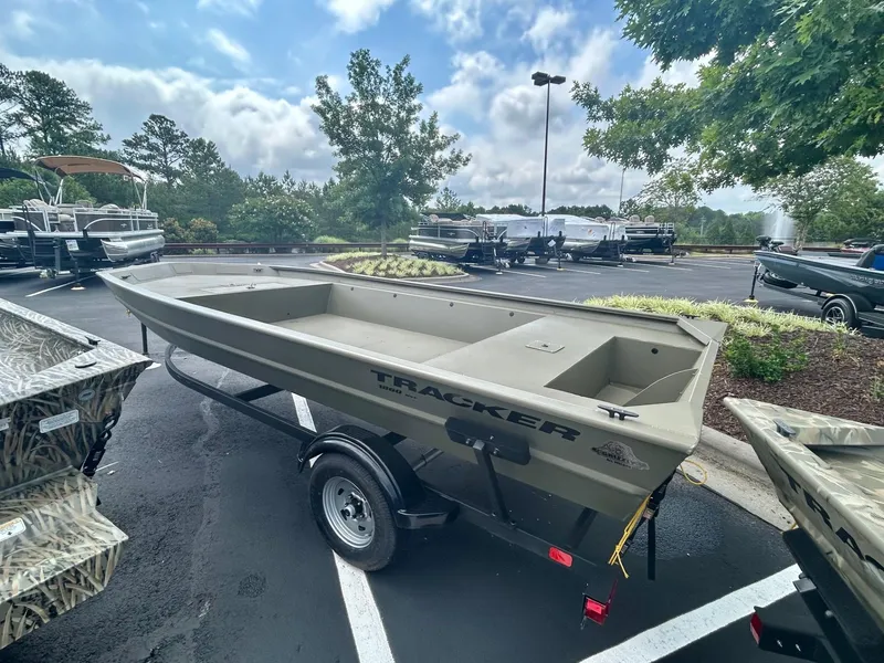 Slide: The Image of 2025 Tracker GRIZZLY 1860 Utility boat on trailer in parking lot. - 2