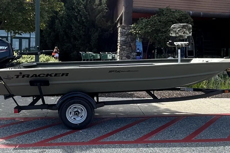 The Image of 2025 Tracker Grizzly 1654 T Sportsman boat on trailer, parked outdoors. - 0