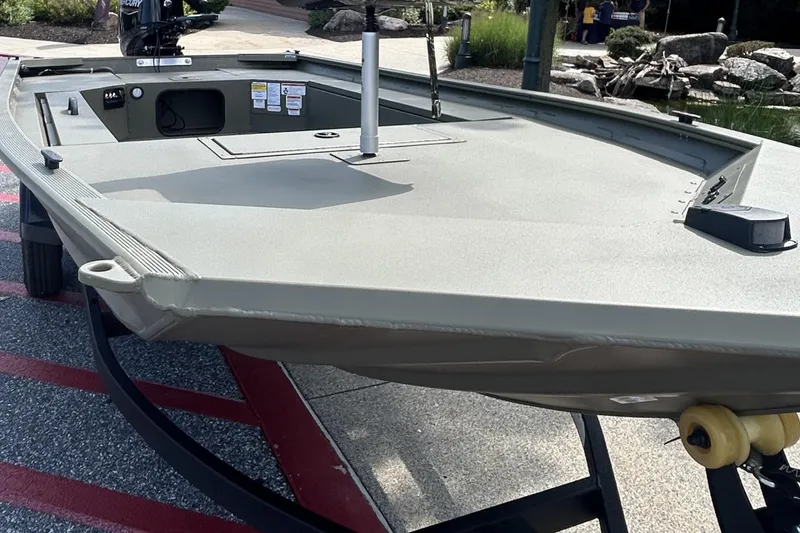 Slide: The Image of 2025 Tracker Grizzly 1654 T Sportsman boat on trailer, outdoor display setting. - 2