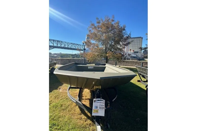 Slide: The Image of 2025 Tracker Grizzly 2072 Utility boat displayed outdoors near a bridge and building. - 15