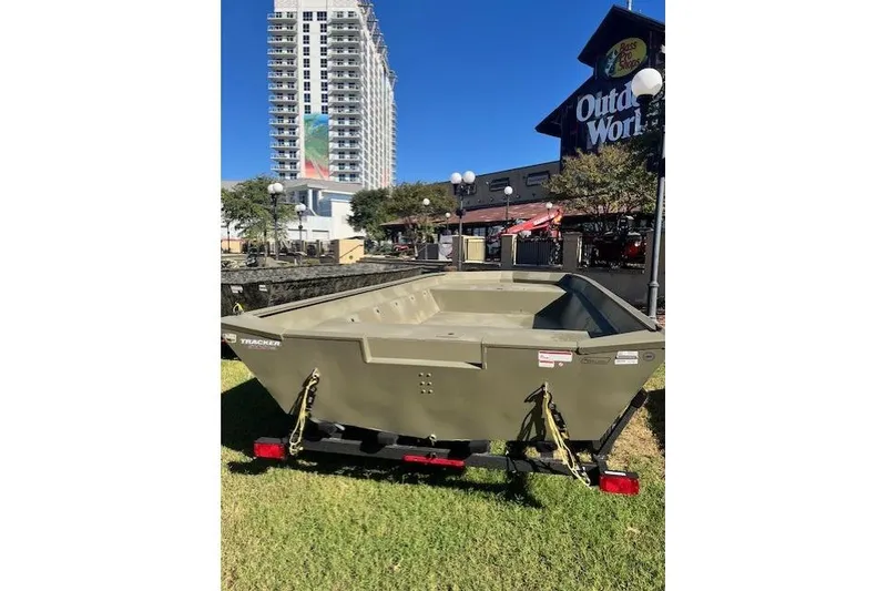 Slide: The Image of 2025 Tracker Grizzly 2072 Utility boat on trailer, outdoor setting, cityscape background. - 16