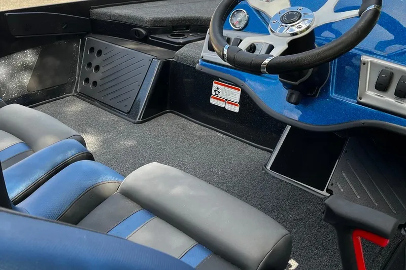 Slide: The Image of Interior of a 2025 Nitro Z18 boat featuring blue and black seating and steering console. - 8