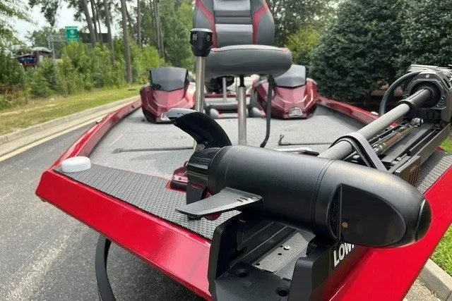 Slide: The Image of 2025 Ranger RT188P bass boat with trolling motor, red and black design, parked outdoors. - 2