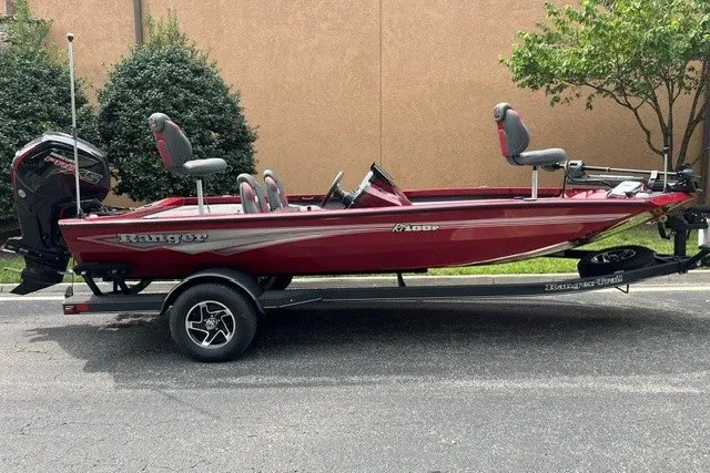 The Image of 2025 Ranger RT188P boat in red on a trailer, parked outdoors. - 0