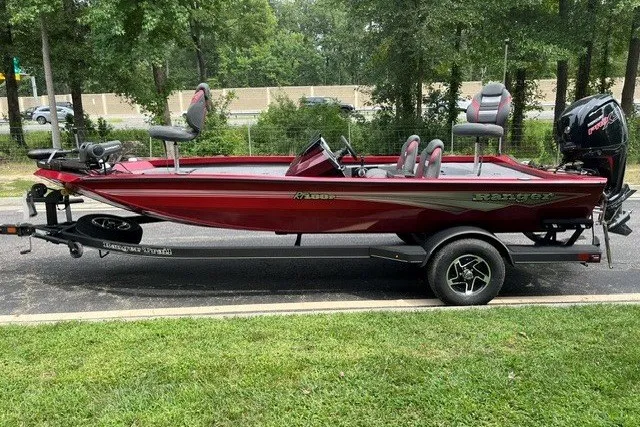 Slide: The Image of 2025 Ranger RT188P boat in red on a trailer, parked outdoors. - 1