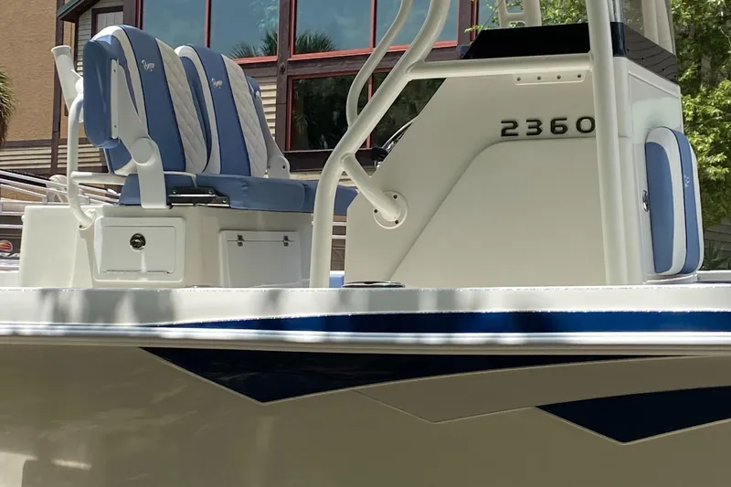 Slide: The Image of 2025 Ranger 2360 Bay boat with blue and white seating, docked outdoors. - 3