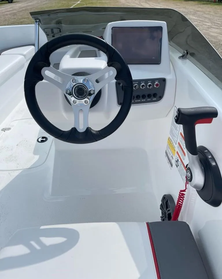 Slide: The Image of 2025 Tahoe T16 boat with outboard motor, parked outdoors on gravel. - 6