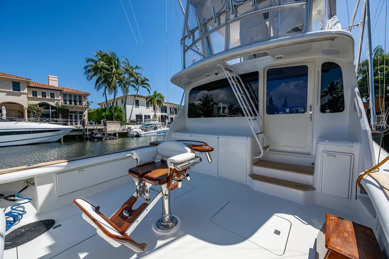 Slide: The Image of 1999 Ocean Yachts 60 Convertible yacht with fishing chairs, docked in a sunny marina. - 1