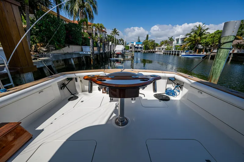 Slide: The Image of 1999 Ocean Yachts 60 Convertible, spacious deck, canal view, palm trees, sunny day. - 12