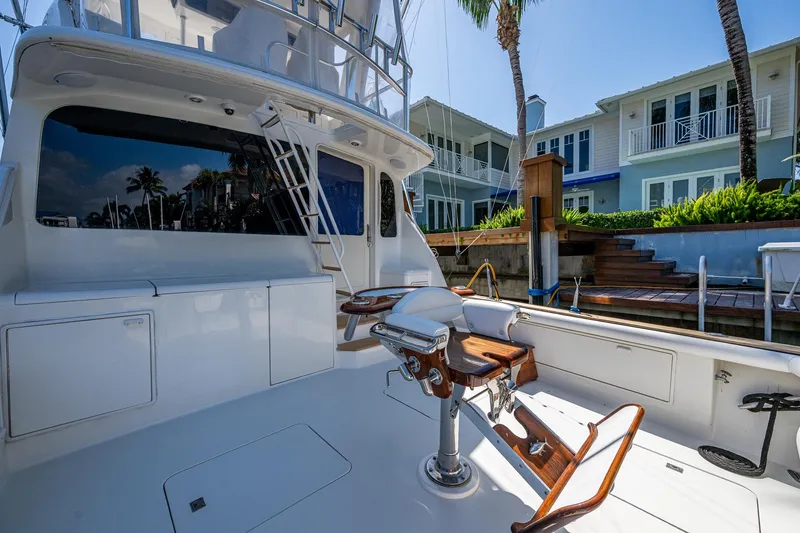 Slide: The Image of 1999 Ocean Yachts 60 Convertible yacht deck with fishing chair, docked near waterfront homes. - 14