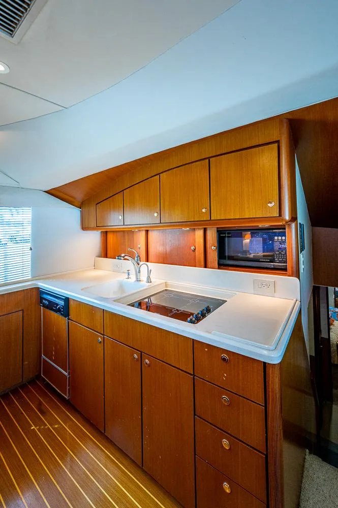 Slide: The Image of 1999 Ocean Yachts 60 Convertible kitchen with wooden cabinets and modern appliances. - 20