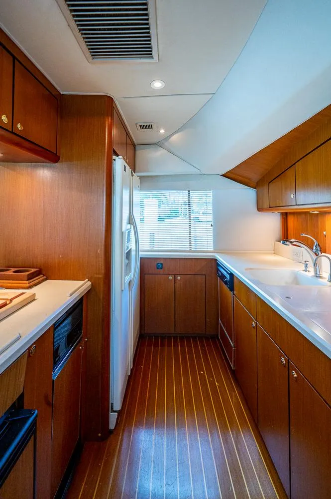 Slide: The Image of 1999 Ocean Yachts 60 Convertible kitchen with wood cabinetry and modern appliances. - 23