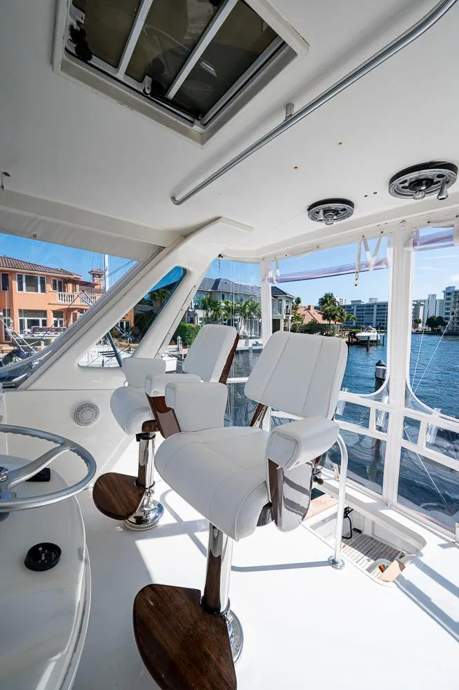Slide: The Image of 1999 Ocean Yachts 60 Convertible interior with white seating and waterfront view. - 43