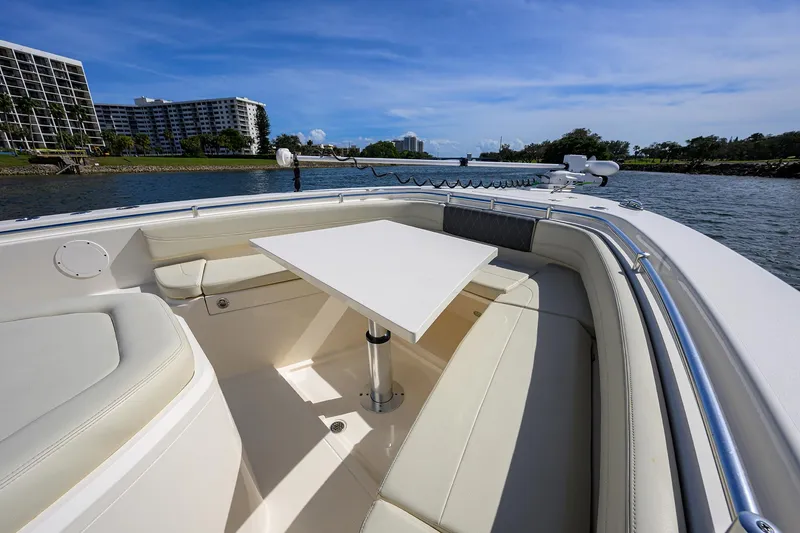 Slide: The Image of 2022 Cobia 350 Center Console boat with seating and table, cruising on a sunny day. - 11
