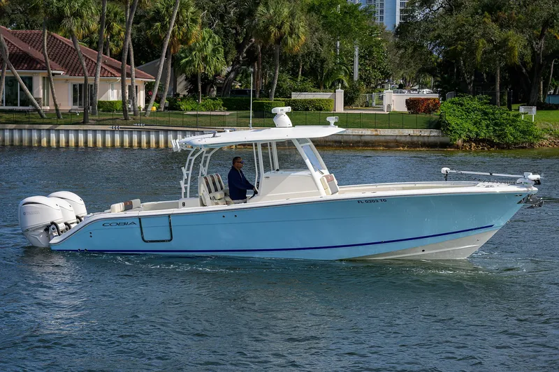 Slide: The Image of 2022 Cobia 350 Center Console boat cruising on a calm waterway. - 2