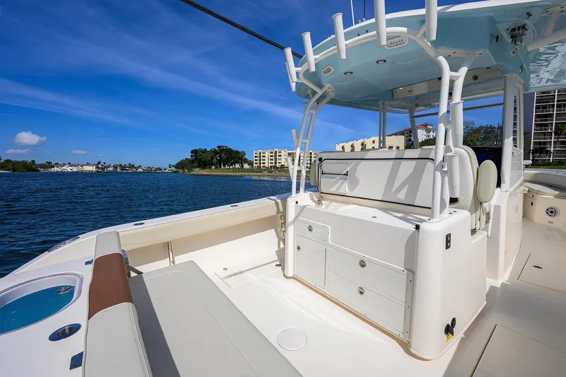 Slide: The Image of 2022 Cobia 350 Center Console boat on calm water, showcasing spacious seating and clear blue sky. - 20