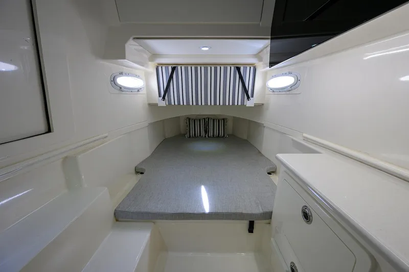 Slide: The Image of 2022 Cobia 350 Center Console cabin interior with bed and portholes. - 27