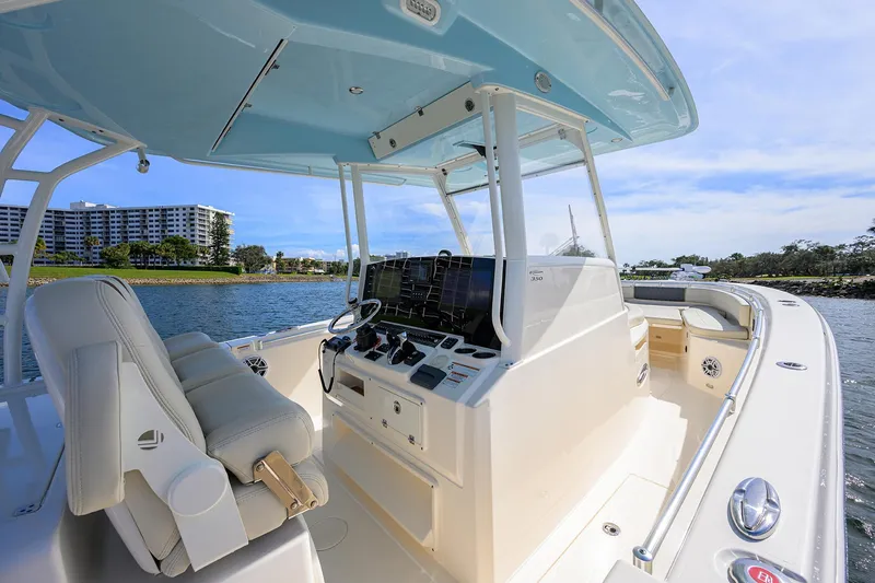 Slide: The Image of 2022 Cobia 350 Center Console boat interior with modern controls and seating on a sunny day. - 31