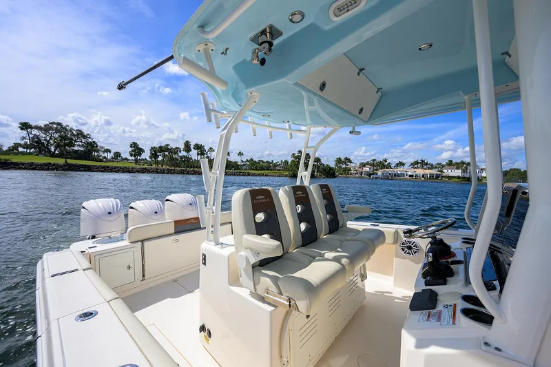 Slide: The Image of 2022 Cobia 350 Center Console boat interior with seating and controls on a sunny day. - 33