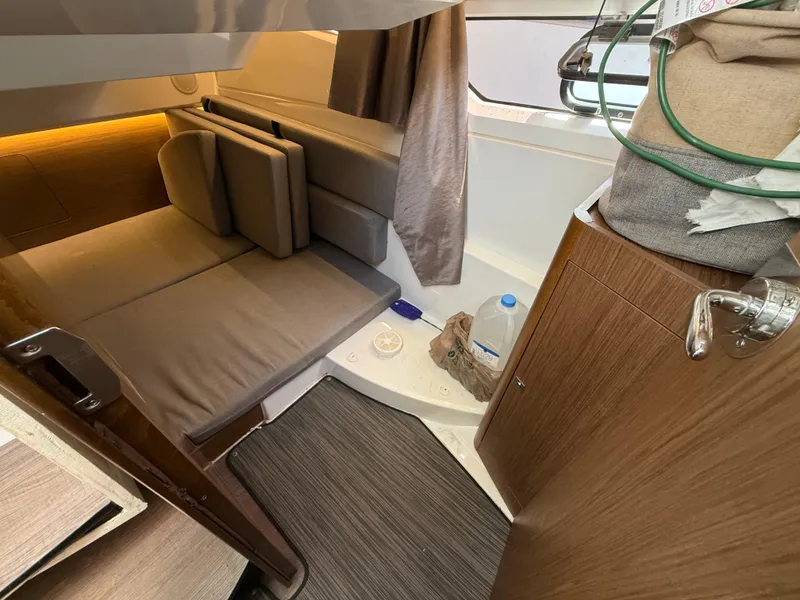 Slide: The Image of 2018 Jeanneau NC 895 cabin interior with seating, storage, and window view. - 13