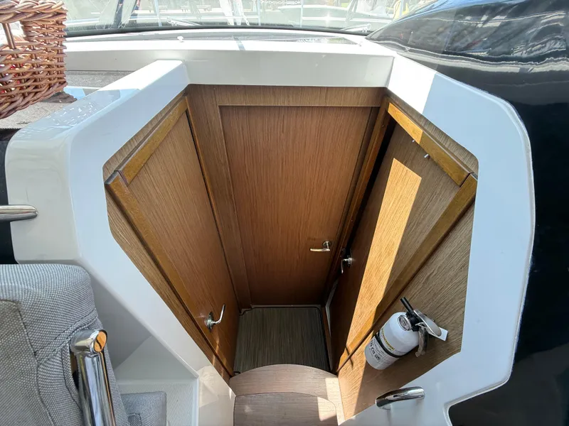 Slide: The Image of Interior view of 2018 Jeanneau NC 895 boat showing wooden cabin doors and a fire extinguisher. - 14