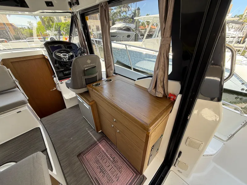 Slide: The Image of Interior of 2018 Jeanneau NC 895 boat, featuring helm and wooden cabinetry. - 19