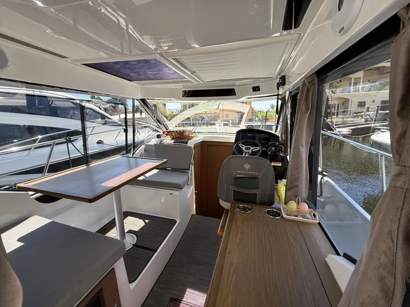 Slide: The Image of Interior of 2018 Jeanneau NC 895 boat with seating, table, and helm station. - 23