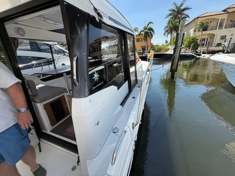 Slide: The Image of 2018 Jeanneau NC 895 docked near waterfront homes and palm trees. - 24