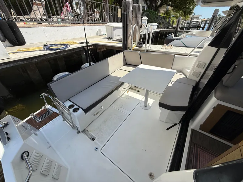 Slide: The Image of 2018 Jeanneau NC 895 boat deck with seating and table, docked at marina. - 29
