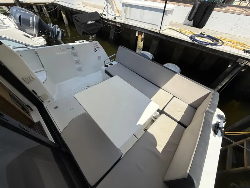 Slide: The Image of 2018 Jeanneau NC 895 boat with spacious seating area and table, docked at marina. - 30