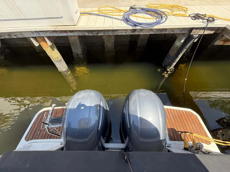 Slide: The Image of Twin outboard engines on a 2018 Jeanneau NC 895 docked by a wooden pier. - 6
