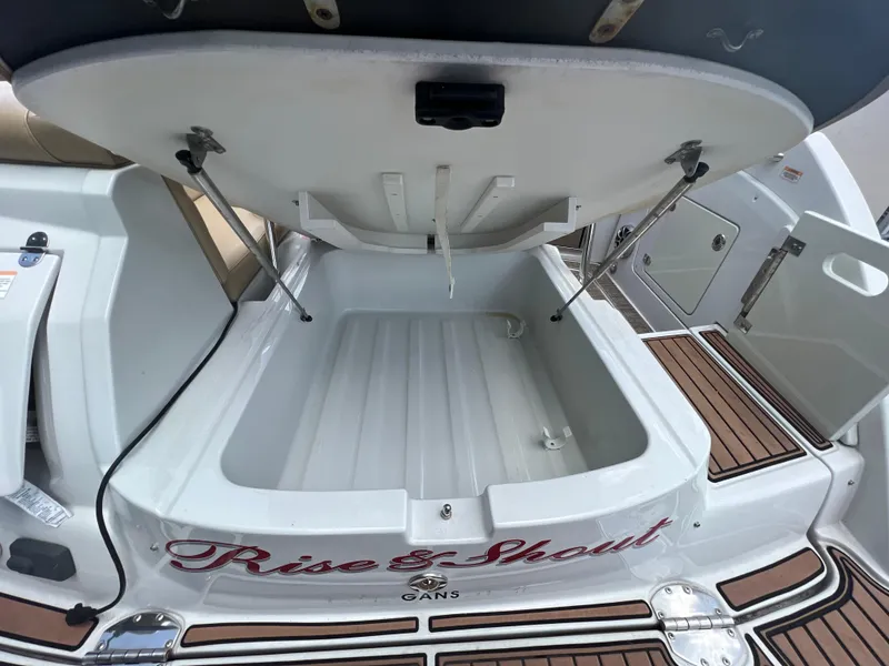 Slide: The Image of 2017 Crownline 294 CR boat storage compartment open, showcasing spacious interior and deck details. - 15