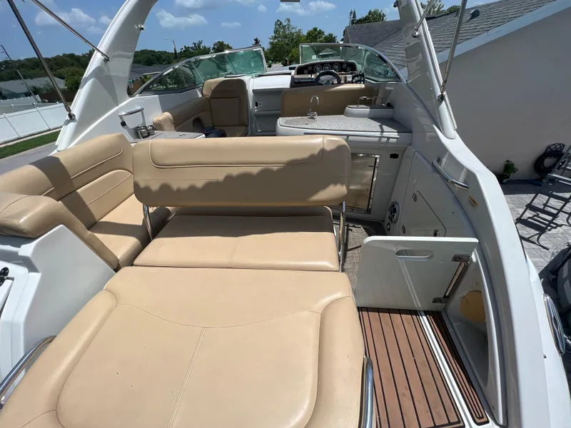 Slide: The Image of 2017 Crownline 294 CR boat interior with beige seating and wooden flooring. - 16