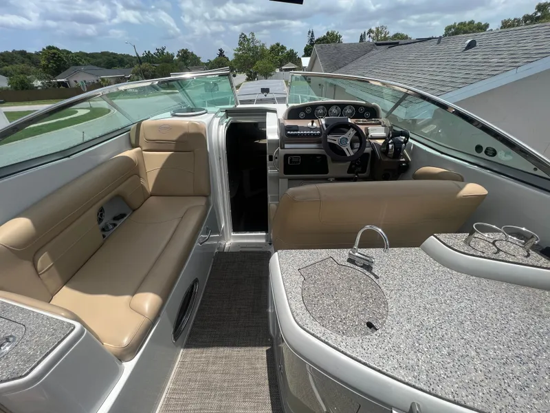 Slide: The Image of 2017 Crownline 294 CR boat interior with beige seating and modern dashboard. - 17