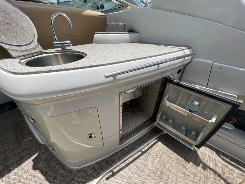 Slide: The Image of 2017 Crownline 294 CR boat interior with sink and open mini fridge. - 19