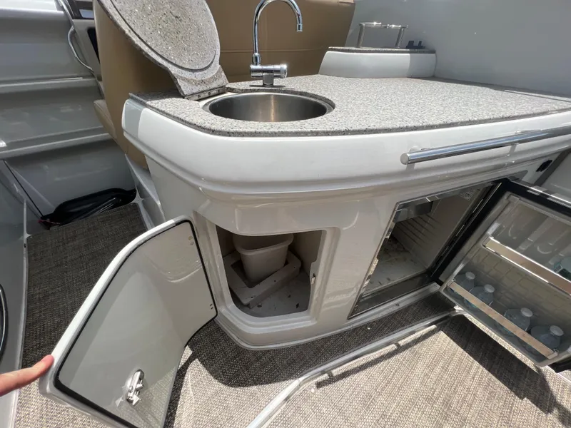 Slide: The Image of 2017 Crownline 294 CR boat kitchenette with sink, storage, and mini-fridge. - 20