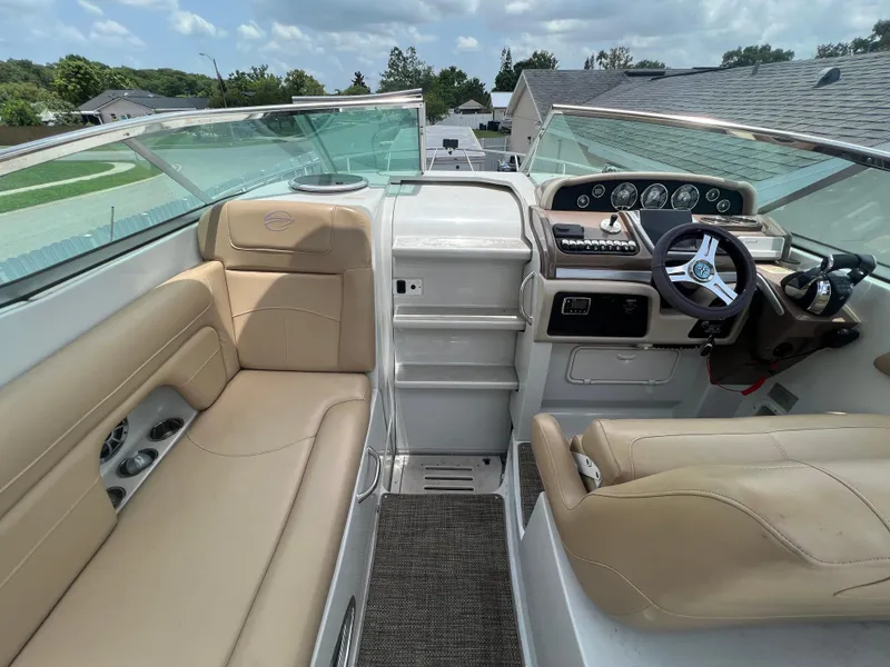 Slide: The Image of 2017 Crownline 294 CR boat interior with beige seating and modern dashboard. - 27