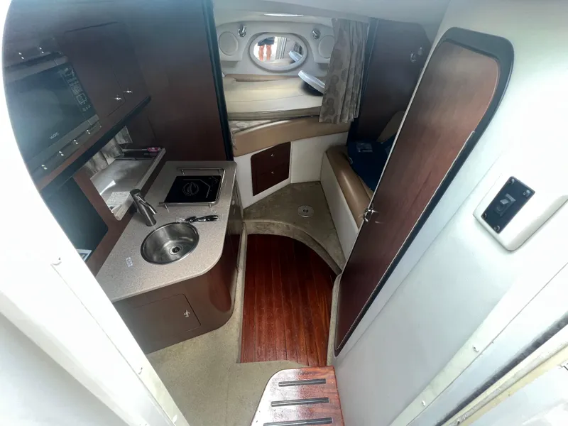 Slide: The Image of Interior of 2017 Crownline 294 CR boat with kitchenette and seating area. - 31