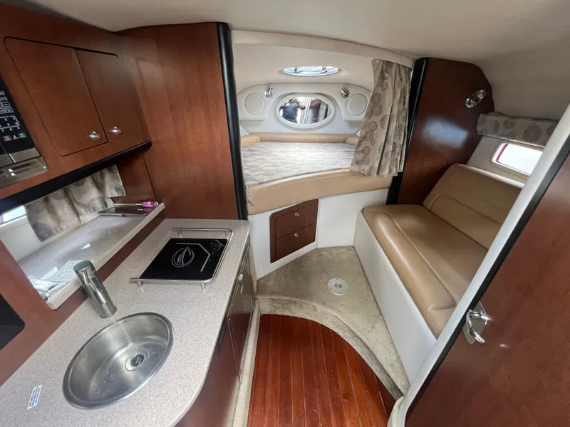 Slide: The Image of 2017 Crownline 294 CR cabin interior with kitchenette, seating, and sleeping area. - 32