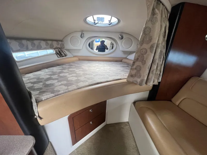 Slide: The Image of 2017 Crownline 294 CR cabin interior with bed, storage, and seating. - 33