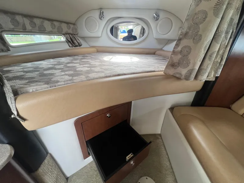 Slide: The Image of 2017 Crownline 294 CR cabin interior with bed, storage, and curtains. - 35